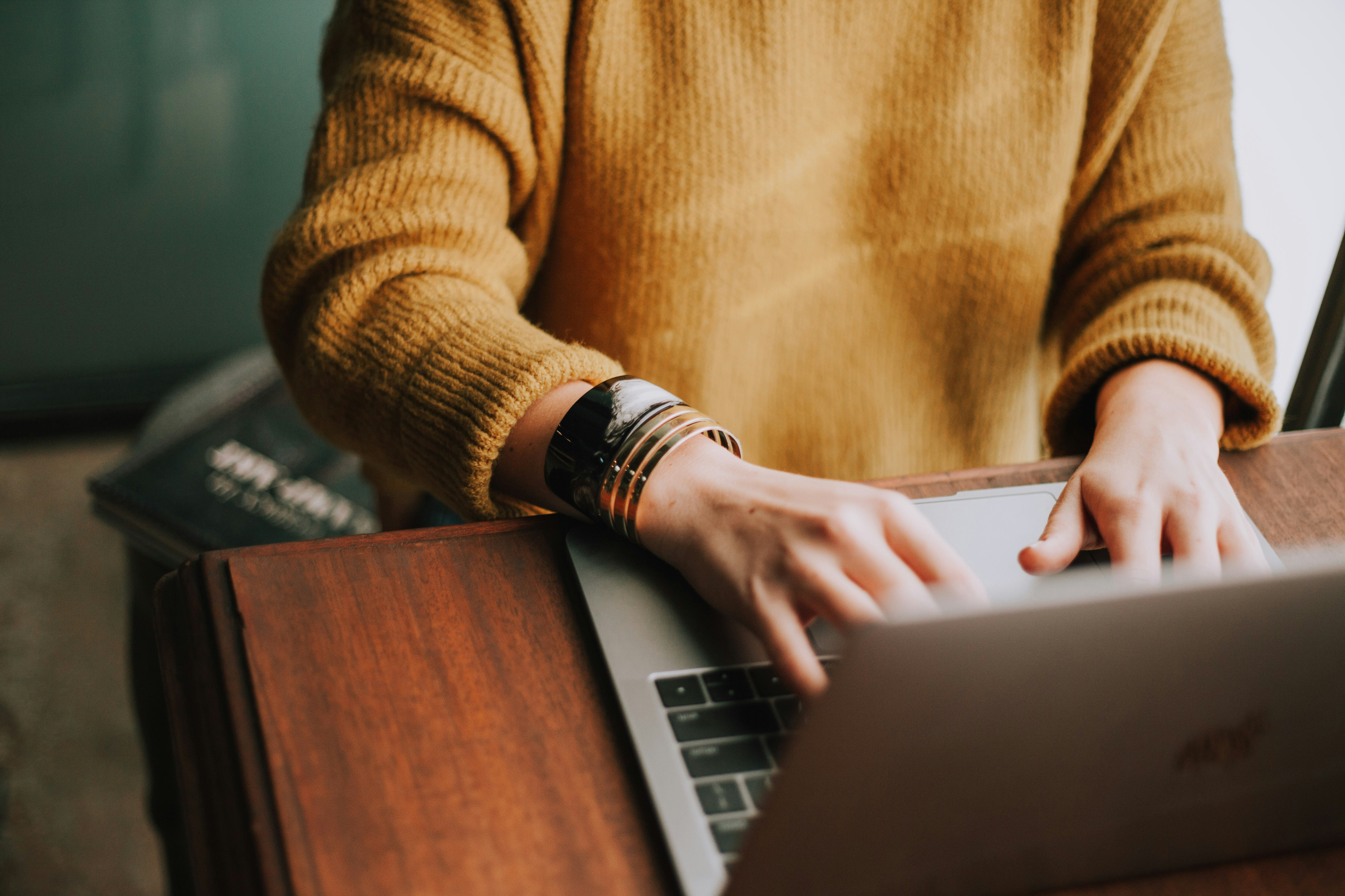 Young woman using laptop to type a document.